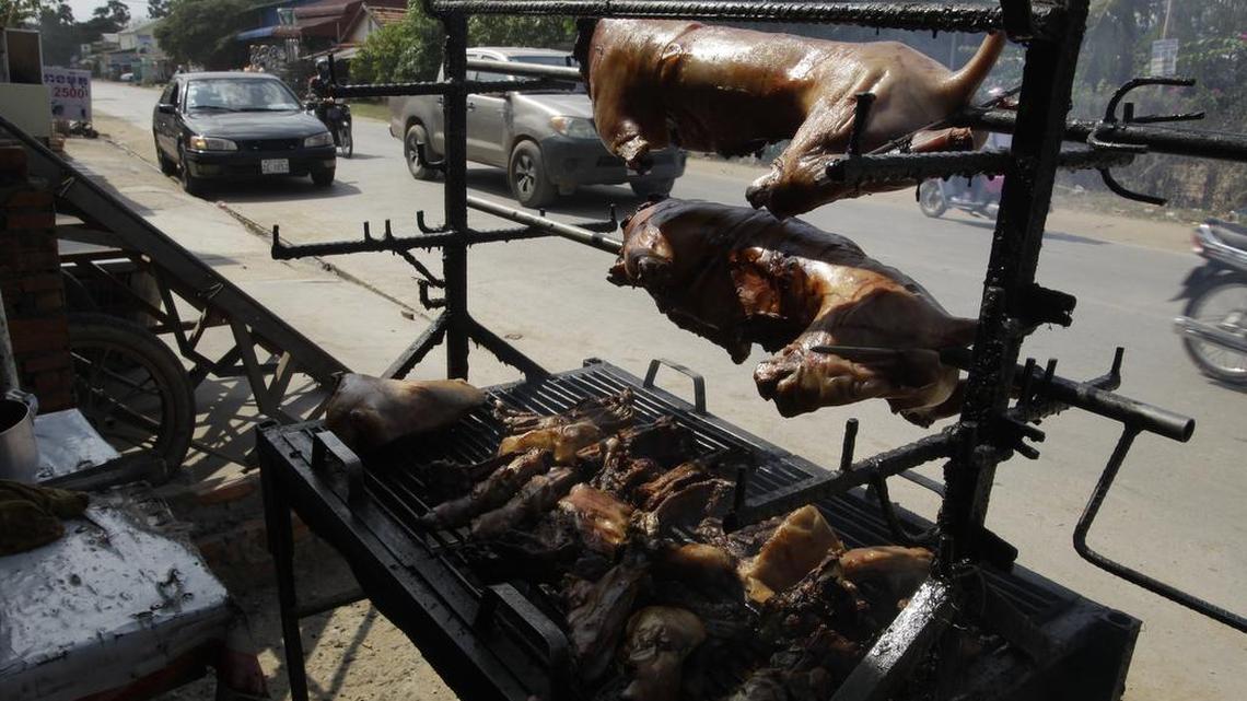 Un vendedor local exhibe las carnes asadas de perro en una acera fuera de Phnom Penh, jueves, el 30 de marzo de 2017.