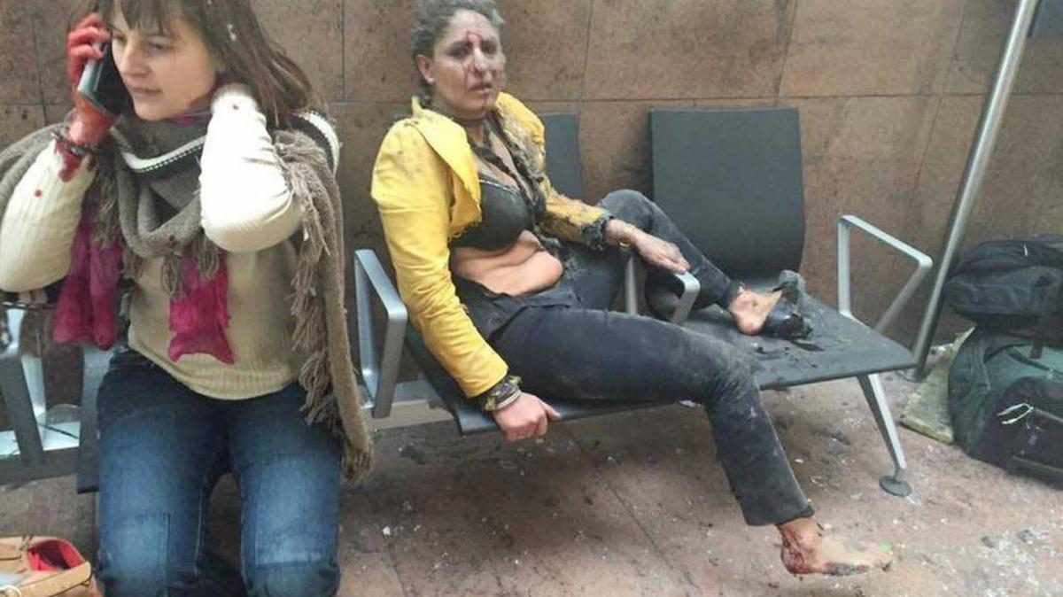Foto de archivo del 22 de marzo de 2016 muestra a una mujer herida y otra hablando en su teléfono después de explosiones en el aeropuerto de Bruselas.