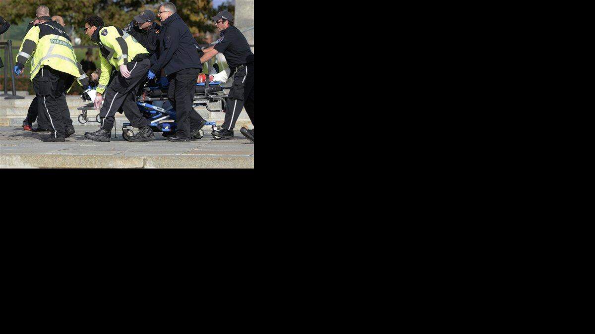 Paramédicos y policías sacan a una víctima del Memorial Nacional de Guerra de Canadá en Ottawa el miércoles, 22 de octubre del 2014. Un soldado que montaba guardia en el memorial fue herido de bala por un pistolero que testigos dicen ingresó posteriormente al edificio del parlamento.