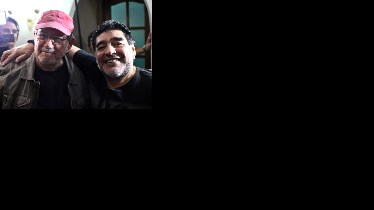 
El exfutbolista argentino Diego Armando Maradona (d) y cantautor cubano Silvio Rodríguez (i) posan para una fotografía el viernes 9 de enero de 2015, tras un concierto de Rodríguez en su primera presentación de 2015 en la "Gira por los barrios", un proyecto artístico que inició hace cuatro años, en el barrio "Zamora" del municipio habanero Marianao (Cuba). 