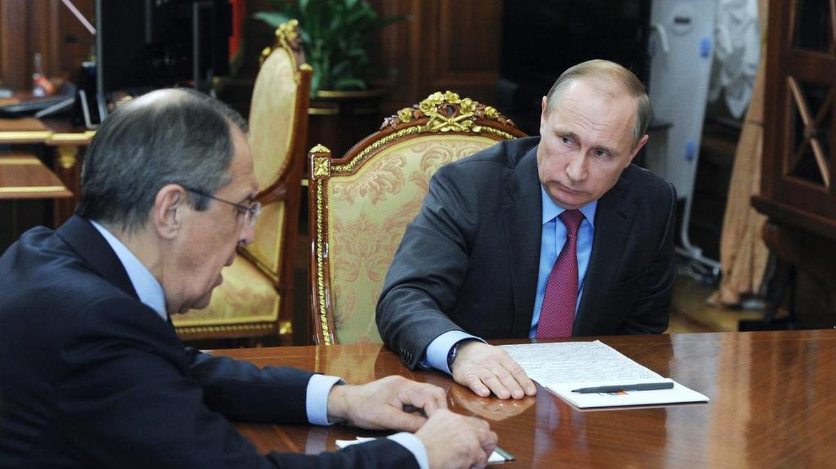 El presidente de Rusia, Vladimir Putin (der.), conversa el lunes con el ministro de Relaciones Exteriores ruso, Sergey Lavrov, durante una reunión en el Kremlin.