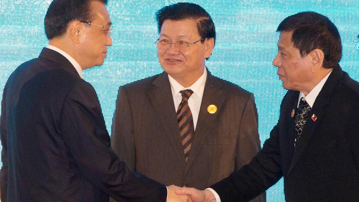 El primer ministro chino, Li Keqiang (izq.), estrecha la mano del presidente filipino, Rodrigo Duterte, en la cumbre de los países del sudeste asiático.