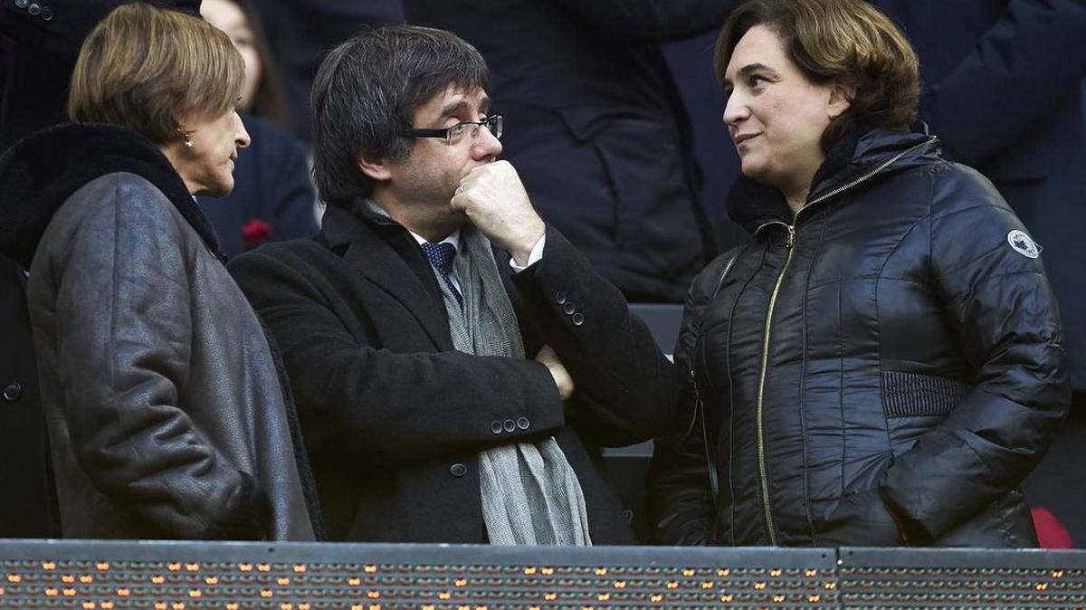 El presidente de la Generalitat, Carles Puigdemont (centro) conversa con la alcaldesa de Barcelona, Ada Colau (der.) y la presidenta del Parlamento catalán, Carme Forcadell durante el partido de la decimocuarta jornada de Liga entre el FC Barcelona y el Real Madrid, el 3 de diciembre de 2016.