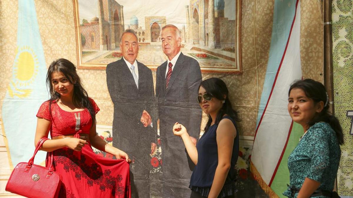 Mujeres uzbekas se forografían en Tashkent delante de un cuadro del presidente Karimov (derecha) y su par kazajo Nursultan Nazarbaev.