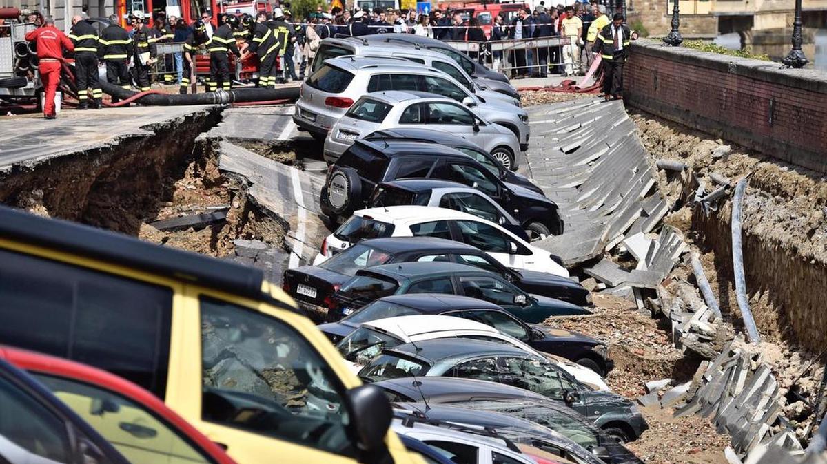 Los servicios de emergencia trabajan el miércoles junto a los vehículos engullidos por un socavón en el centro de la ciudad italiana de Florencia.