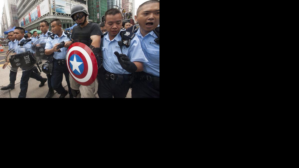 Policías hongkoneses arrestan a un activista prodemocrático con un escudo del "Capitán América" en Hong Kong (China), el viernes 24 de octubre de 2014.
