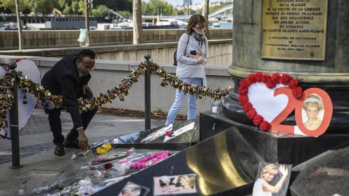 Varias personas dejan flores y fotografías en el monumento de la Llama de la Libertad sobre el puente del Almá en honor a la difunta princesa británica Diana de Gales, en París (Francia), el 31 de agosto de 2017.