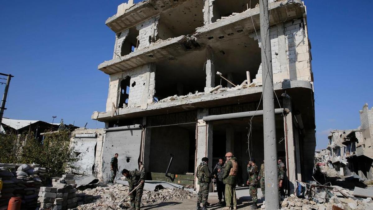 Soldados del ejército ruso y sirio se reúnen en el último puesto de control antes de la línea de frente con los rebeldes, en Karam al-Tarab, al este de Alepo.