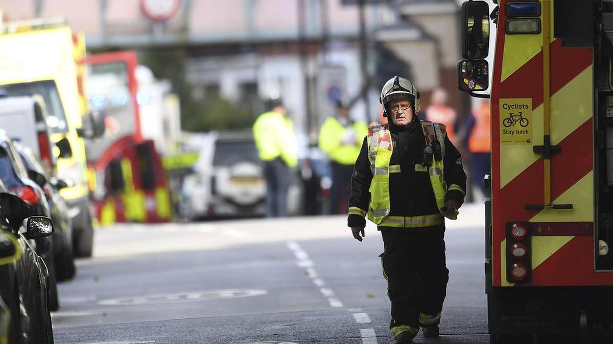 Bomberos y policías caminan junto a la estación de metro Parsons Green en Londres (Reino Unido) hoy, 15 de septiembre de 2017.