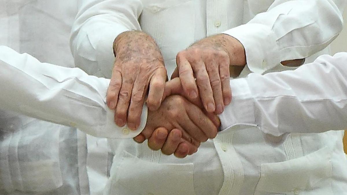 
El gobernante cubano Raúl Castro, centro, une en un saludo las manos del presidente de Colombia Juan Manuel Santos, y el líder guerrillero Timochenko, tras el acuerdo alcanzado en La Habana, este miércoles. 
