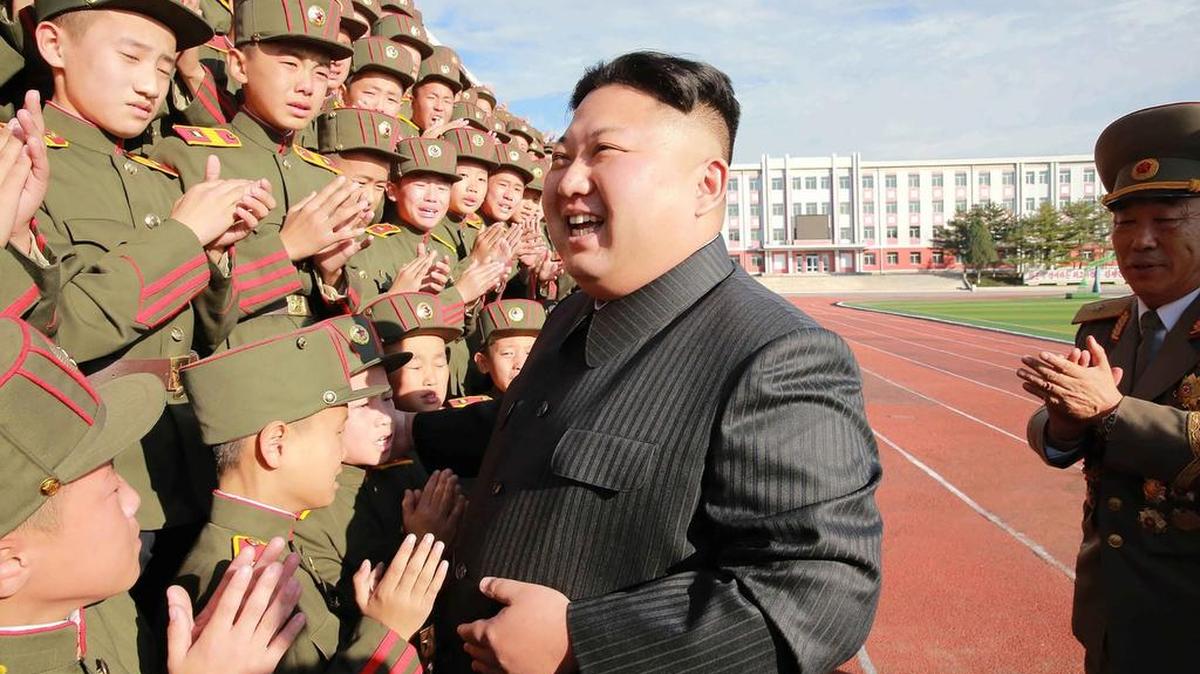 Esta foto sin fecha publicada por la Agencia Coreana de Noticias de Corea del Norte (KCNA) el 13 de octubre de 2017 muestra al líder norcoreano Kim Jong-Un (C) fotografiado con estudiantes y profesores de la Escuela Revolucionaria Mangyongdae en Pyongyang en su 70 aniversario de fundación.