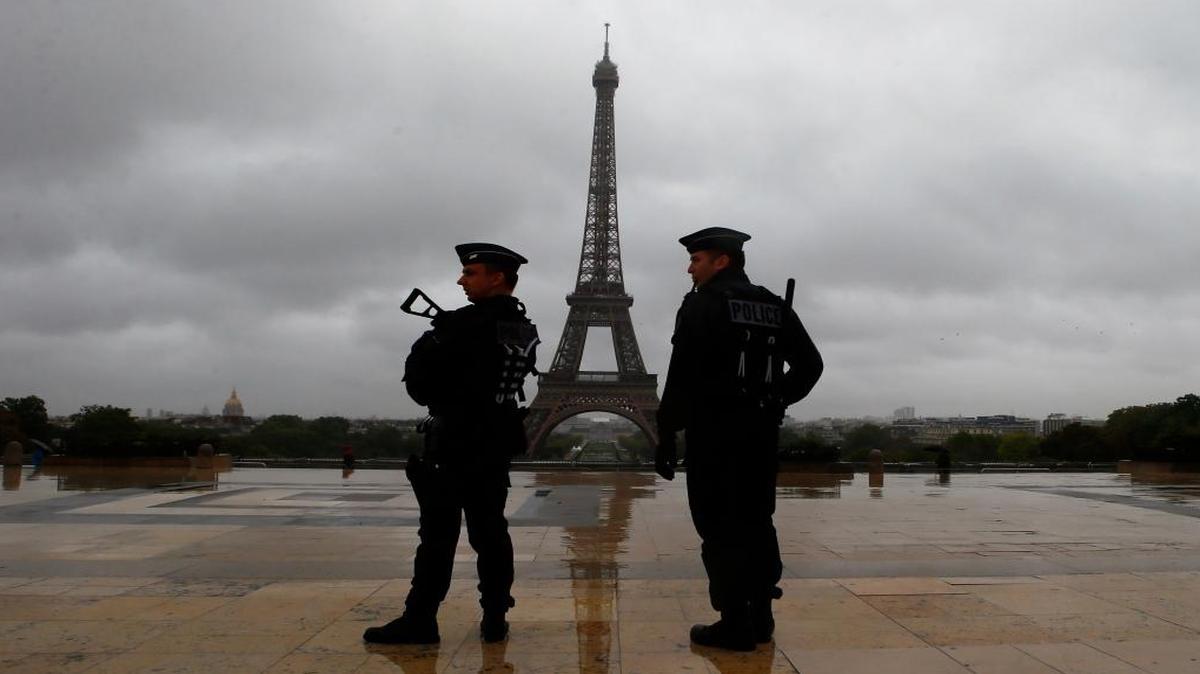 Los policías franceses miran en la plaza de Trocadero que domina la Torre Eiffel.