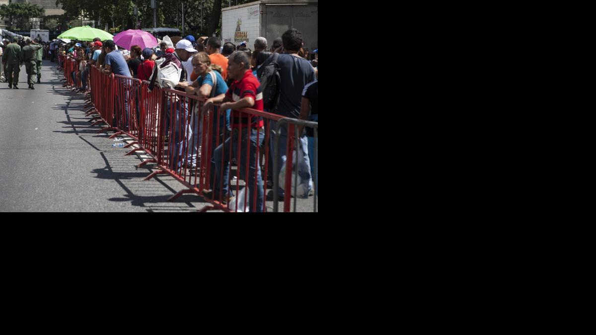 
Un grupo de personas hace fila para ingresar a un punto al aire libre de venta de comida regulada por el Gobierno venezolano el sábado 24 de enero de 2015, en Caracas.
