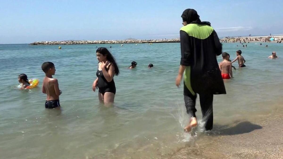 Una mujer se baña en una playa usando un vestido tradicional islámico en Marsella, al sur de Francia. Una segunda localidad de la Riviera francesa, Villeneuve-Loubet, anunció el sábado que prohibiría en sus playas el uso del burkini, traje de baño islámico, después de que Cannes emitiera una ordenanza municipal en el mismo sentido.