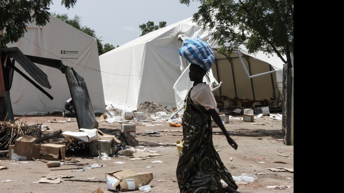 
Una mujer pasa frente a un campamento del Comité Internacional de la Cruz Roja (ICRC), que fue saqueado, en Leer, Sudán, donde se han denunciado repetidamente las violaciones en masa. 
