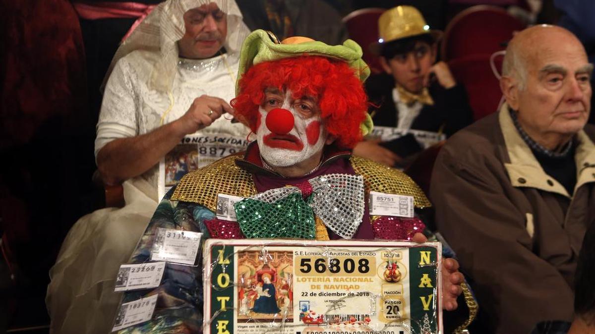 Un hombre disfrazado de payaso espera el número del Gordo de la lotería española, el sábado en el Teatro Real de Madrid.