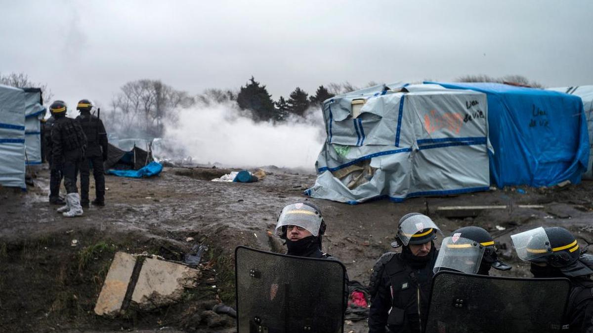 Agentes de policía galos permanecen en guardia el martes en el campamento conocido como “La Jungla” durante las labores de demolición en Calais, Francia.