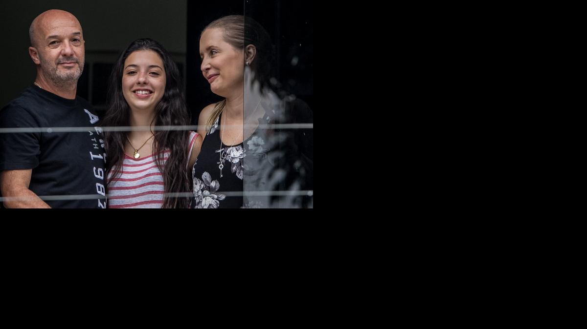 
Ivan Simonovis (i) junto a su esposa Bonny (d) y su hija Ivana (c) sale por la ventana de su casa el sábado 20 de septiembre del 2014, en la ciudad de Caracas (Venezuela), donde Simonovis, condenado a 30 años de prisión por 2 de las 19 muertes registradas durante el golpe de Estado de 2002 a Hugo Chávez, recibió esta madrugada una medida de arresto domiciliario por "razones humanitarias" y ya se encuentra en su casa.
