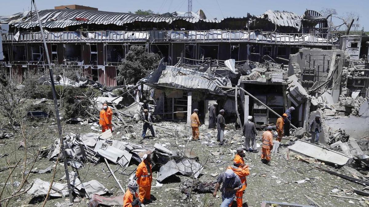 Operarios retiran los escombros junto a uno de los edificios que resultaron seriamente dañados tras el atentado suicida perpetrado ayer en una zona de alta seguridad de Kabul cerca del palacio presidencial, donde se encuentran varias embajadas y edificios del Gobierno, en Afganistán, el 1 de junio de 2017.