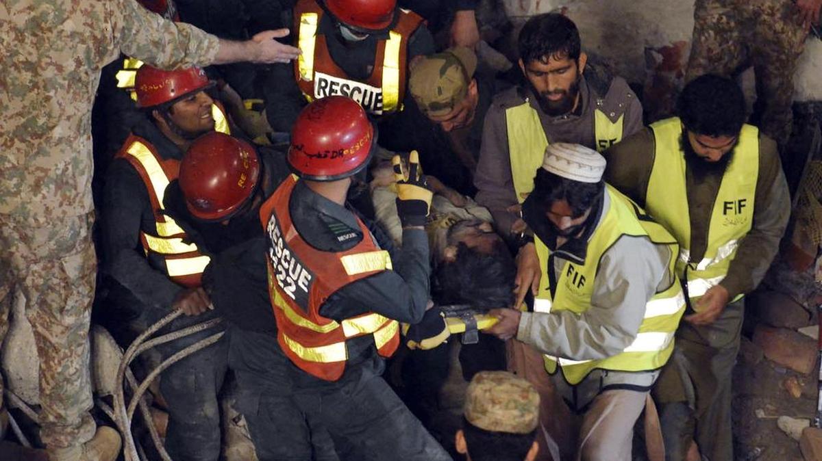 Los equipos de rescate trasladan a una de las víctimas que quedaron atrapadas entre los escombros.