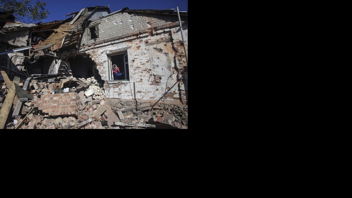 
Una mujer mira por una ventana en una vivienda destruída por proyectiles de artillería en la localidad de Peski, cerca de Donetsk, Ucrania, el viernes.


