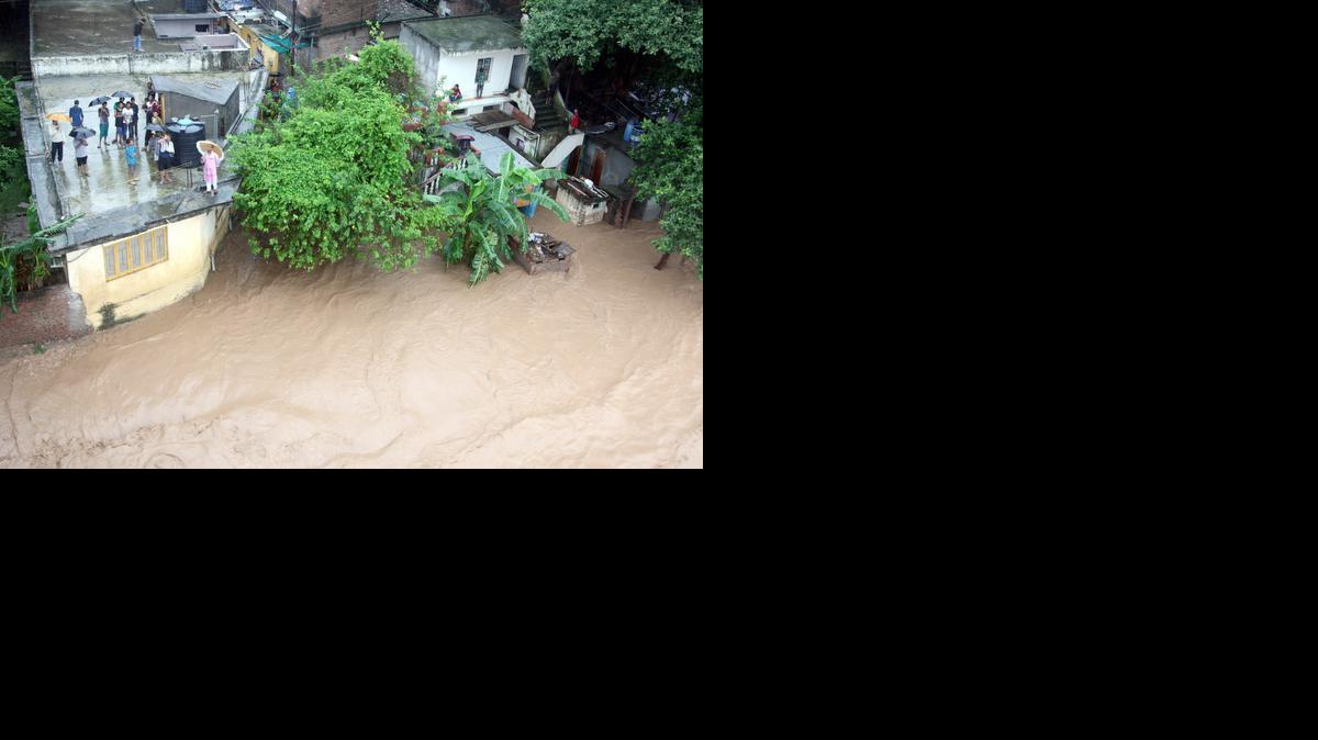 
Personas sobre los techos de sus casas en las orillas del río Tawi esperando ser evacuadas despúes de las intensas lluvias e inundaciones en Jammu, capital de invierno de Cachemira, India, este sábado.


