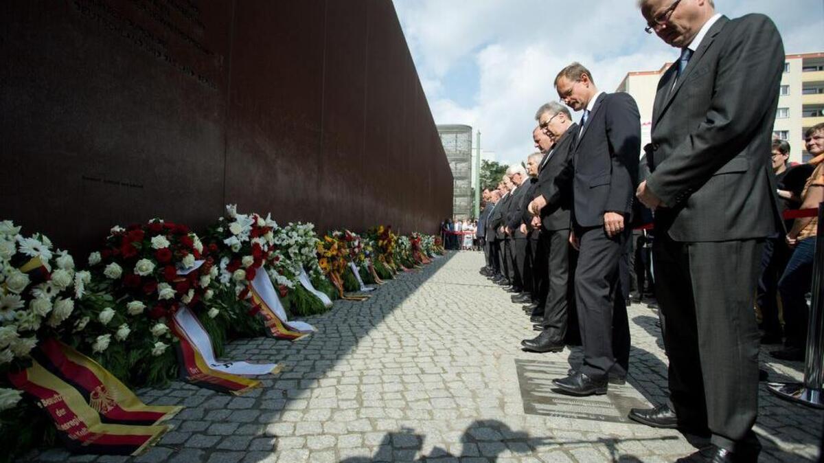 El alcalde de Berlín, Michael Mueller (2do de der. a izq.), junto a otros funcionarios rinden tributo a las víctimas del Muro de Berlín, el sábado, durante la conmemoración de los 55 años del comienzo de su construcción.