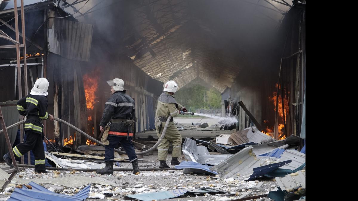 
Varios bomberos trabajan en las labores de extinción de un incendio en un centro comercial tras un bombardeo a las afueras de Donetsk, Ucrania, el miércoles. Ucrania denunció que las milicias rebeldes han lanzado una ofensiva contra las fuerzas gubernamentales en la región de Donetsk.
