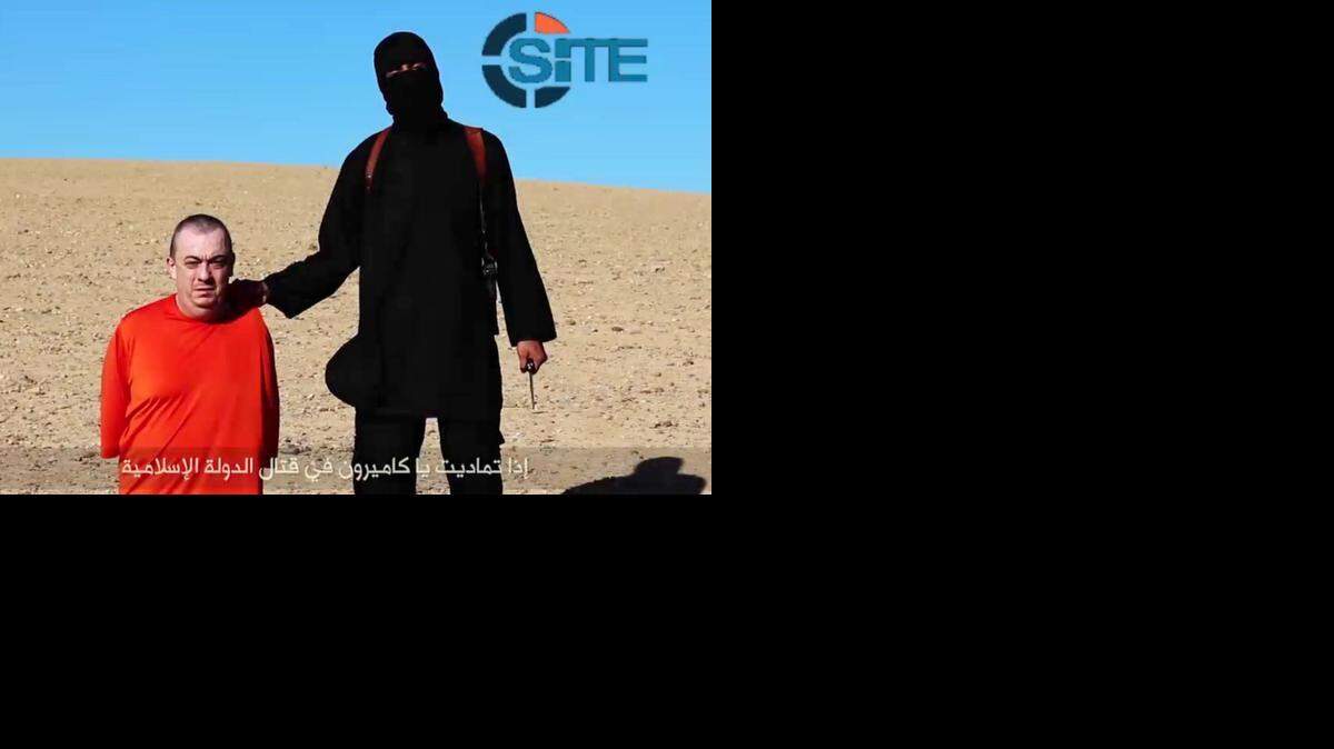 Imagen tomada de un video distribuido por el Estado Islámico que muestra a un terrorista del grupo amenazando con ejecutar al activista británico Alan Henning.