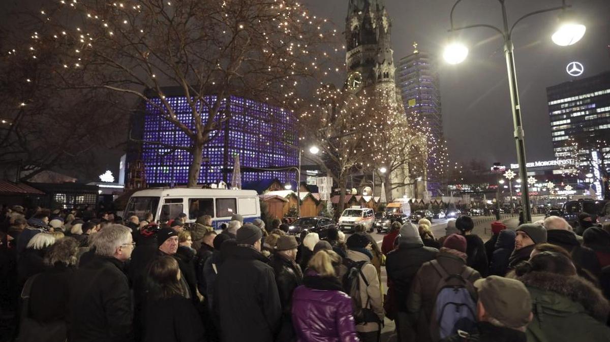 Varias personas se reúnen en memoria de las víctimas del atentado que ayer dejó doce víctimas y numerosos heridos en un mercadillo de Navidad de Berlín, Alemania, hoy 20 de diciembre de 2016.