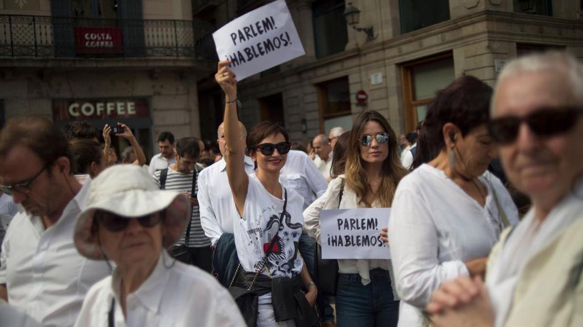 Manifestantes sostienen pancartas en donde piden el dialogo (Parlem, Hablemos) entre el gobierno español y las autoridades catalanas, el sábado en Barcelona, España.
