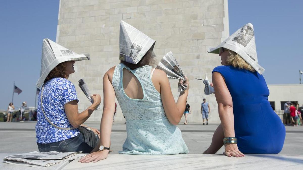 
Visitantes son vistos usando gorros de papel para protegerse en un día caluroso y húmedo en Washington (Estados Unidos). La temperatura la capital estadounidense espera alcanzar los 35 grados con un índice de calor de 38.33 grados. 
