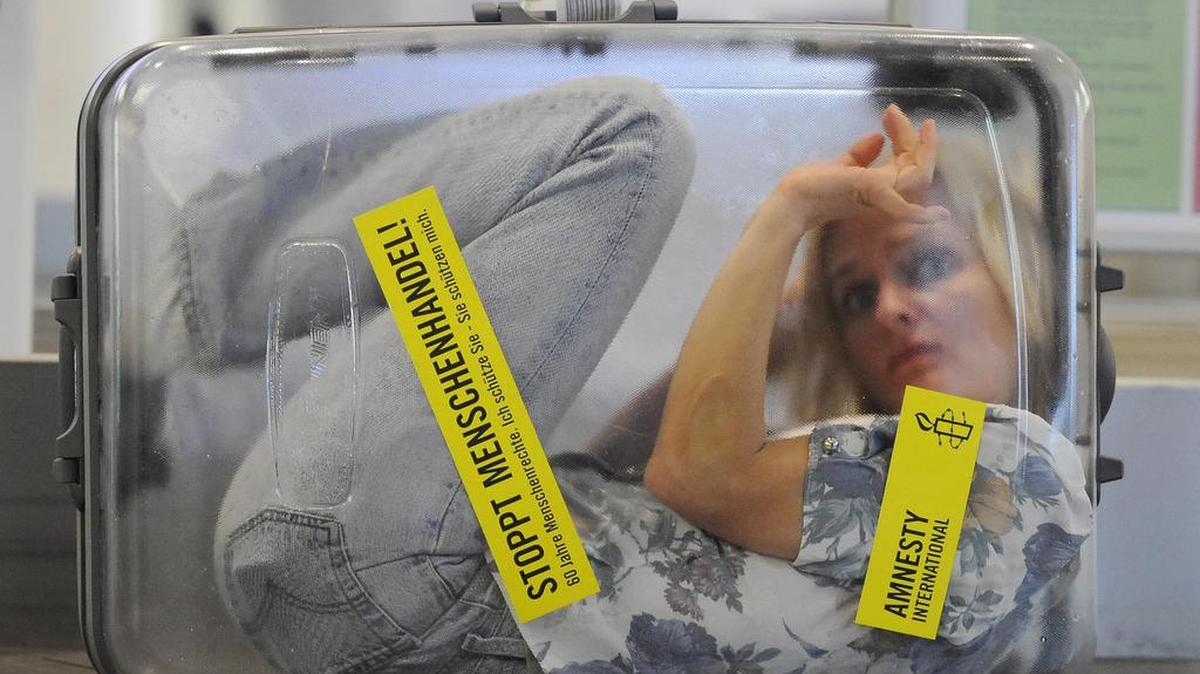 Foto de archivo. Una mujer se encierra en una maleta transparente con el mensaje: "¡Detengan la trata de personas! 60 Años de Derechos Humanos" en el aeropuerto de Munich, sur de Alemania, el 11 de diciembre de 2008.