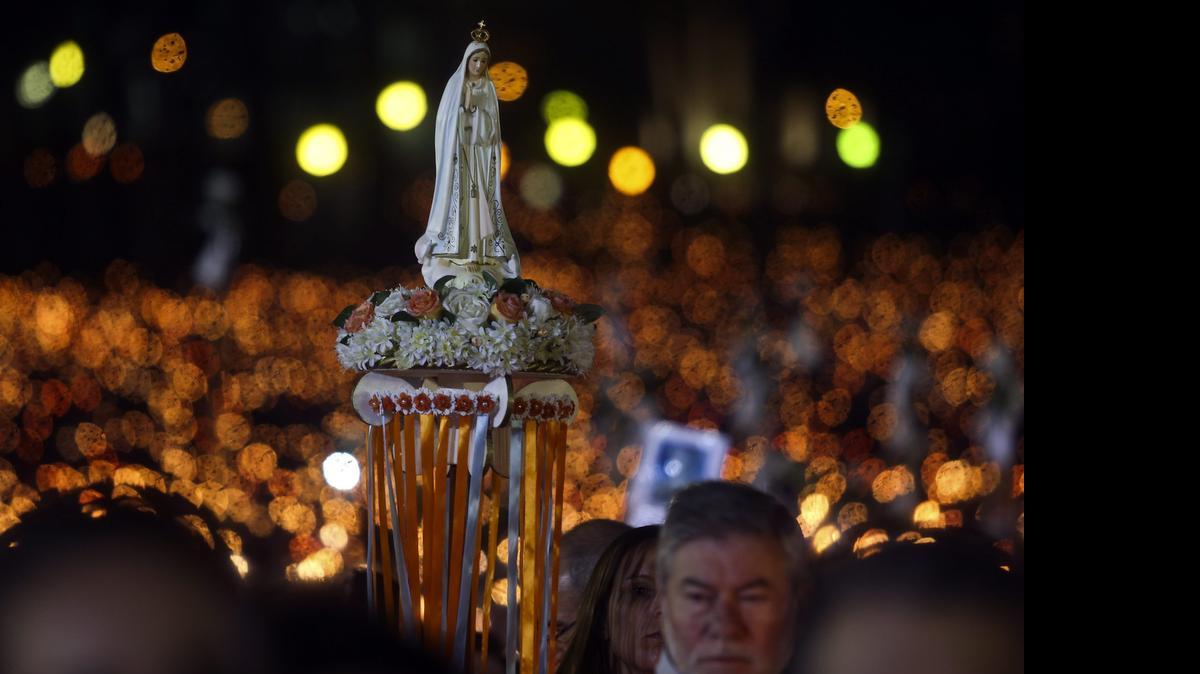 
Peregrinos participan en la Procesión de las Velas cargando la imagen de la virgen hacia el Santuario de Fátima, el martes, en Ourem, Portugal. 
