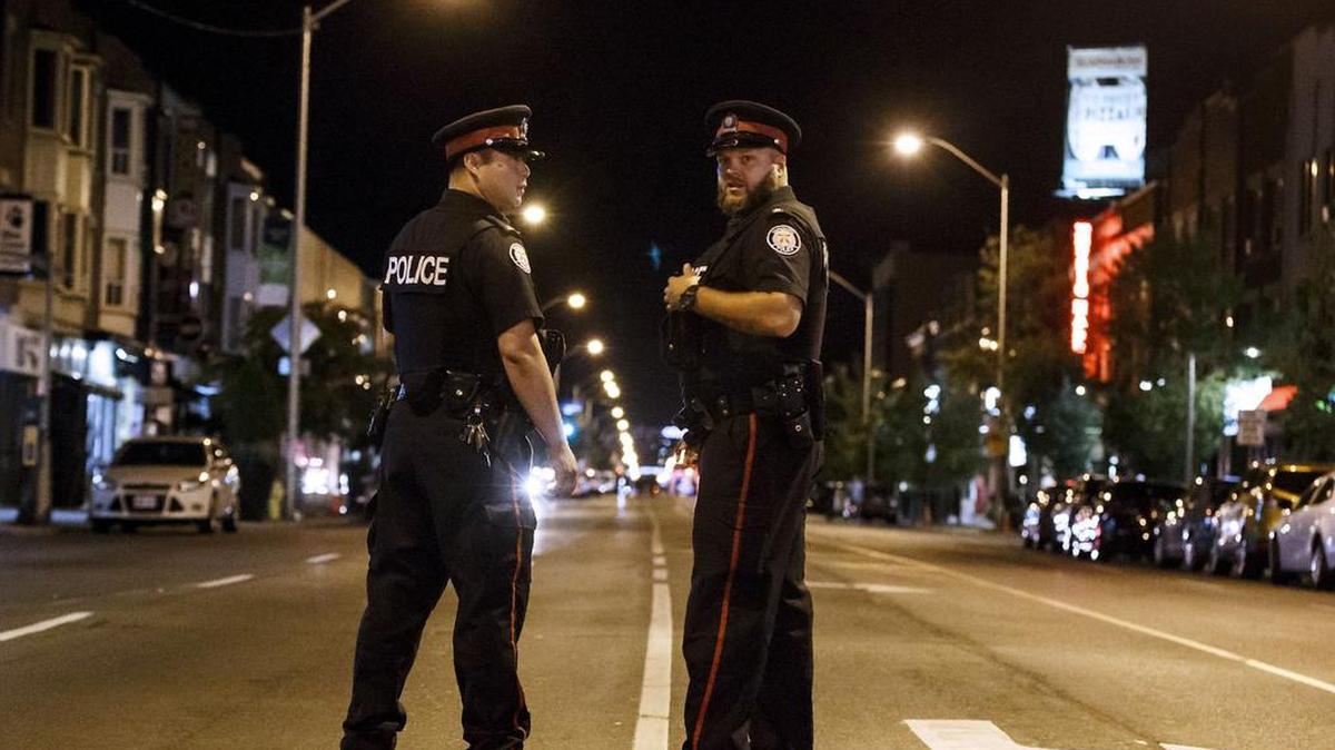 Policías de Toronto vigilan a los pies de la calle Danforth en el lugar de un tiroteo en Toronto, Ontario, Canadá, el 23 de julio de 2018. 
