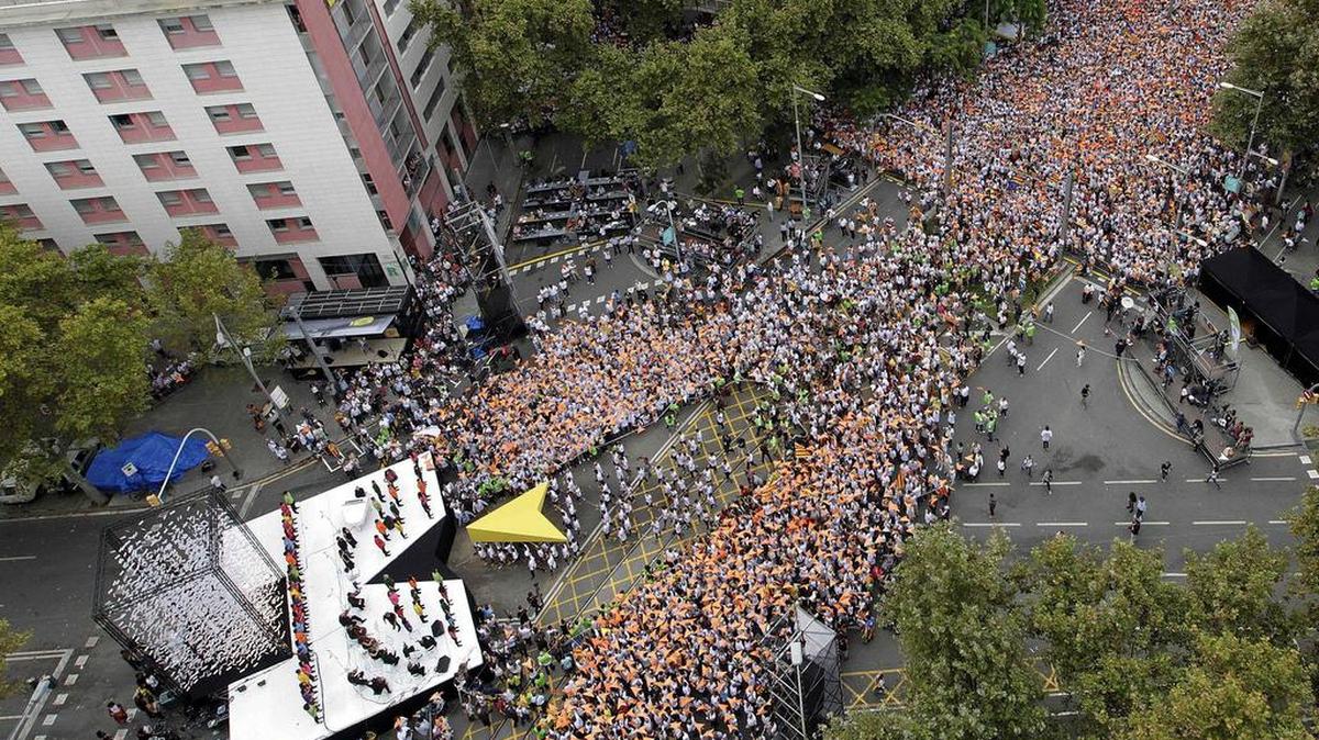 
Miles de personas en la avenida Meridiana de Barcelona durante la gran manifestación por la Diada de Cataluña. En la imagen, un puntero gigante portado por varios deportistas llega al escenario donde tendrán lugar los parlamentos y actuaciones. 
