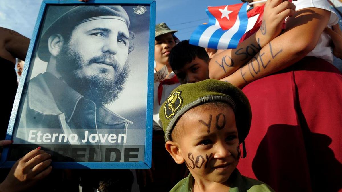 Los niños esperan ver pasar la urna con las cenizas del líder cubano Fidel Castro por las calles de Jimaguayu, Cuba, el 2 de diciembre de 2016, durante su cuatro día de recorrido por la isla para el entierro en Santiago de Cuba.