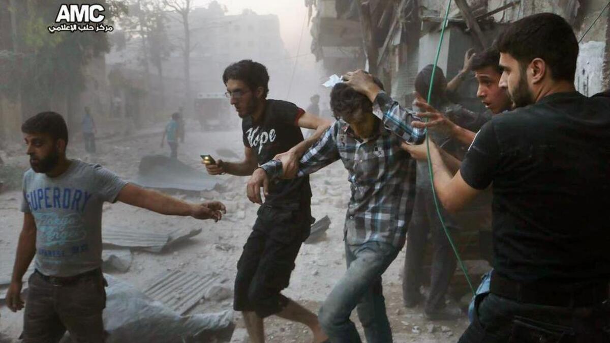 Civiles sirios tratan de protegerse de los bombardeos de la aviación en el área de Aleppo, al este de la capital.