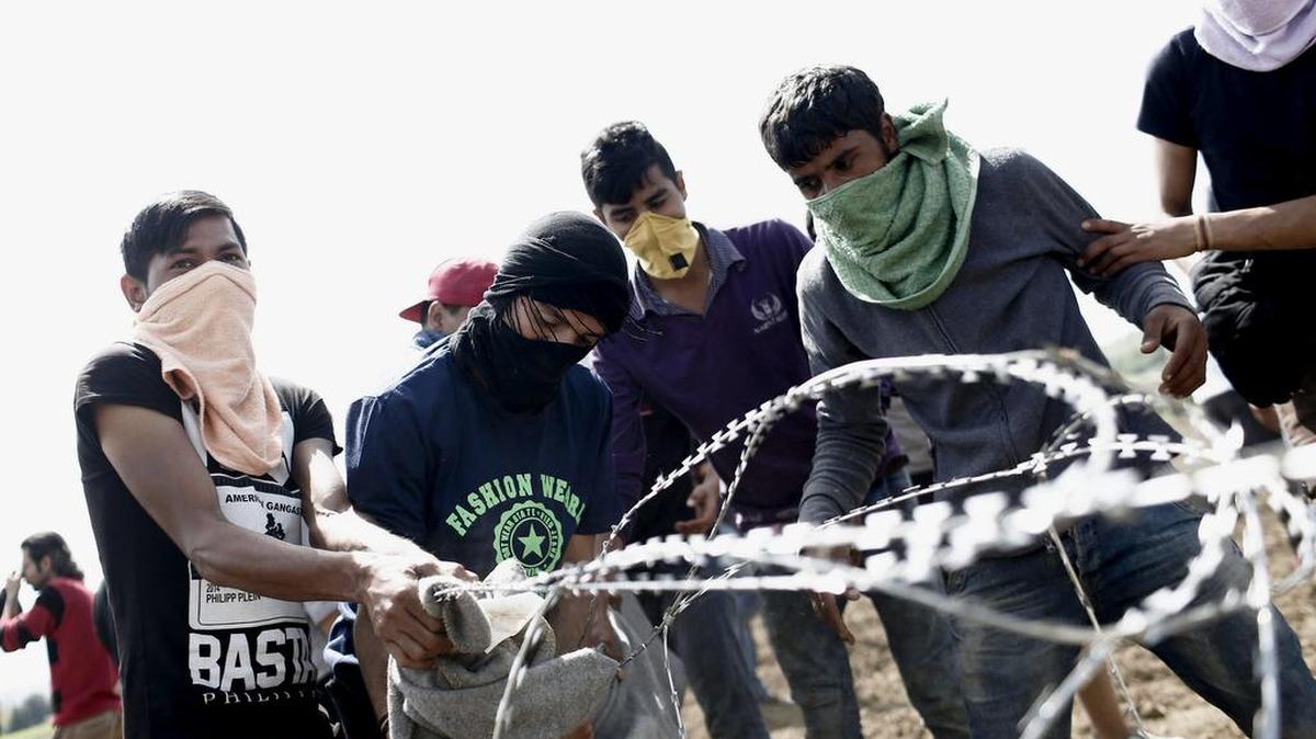 Refugiados tiran el miércoles de una alambrada de espino durante una protesta para pedir la apertura de la frontera en el campo de refugiados de Idomeni, situado en la frontera entre Macedonia y Grecia.