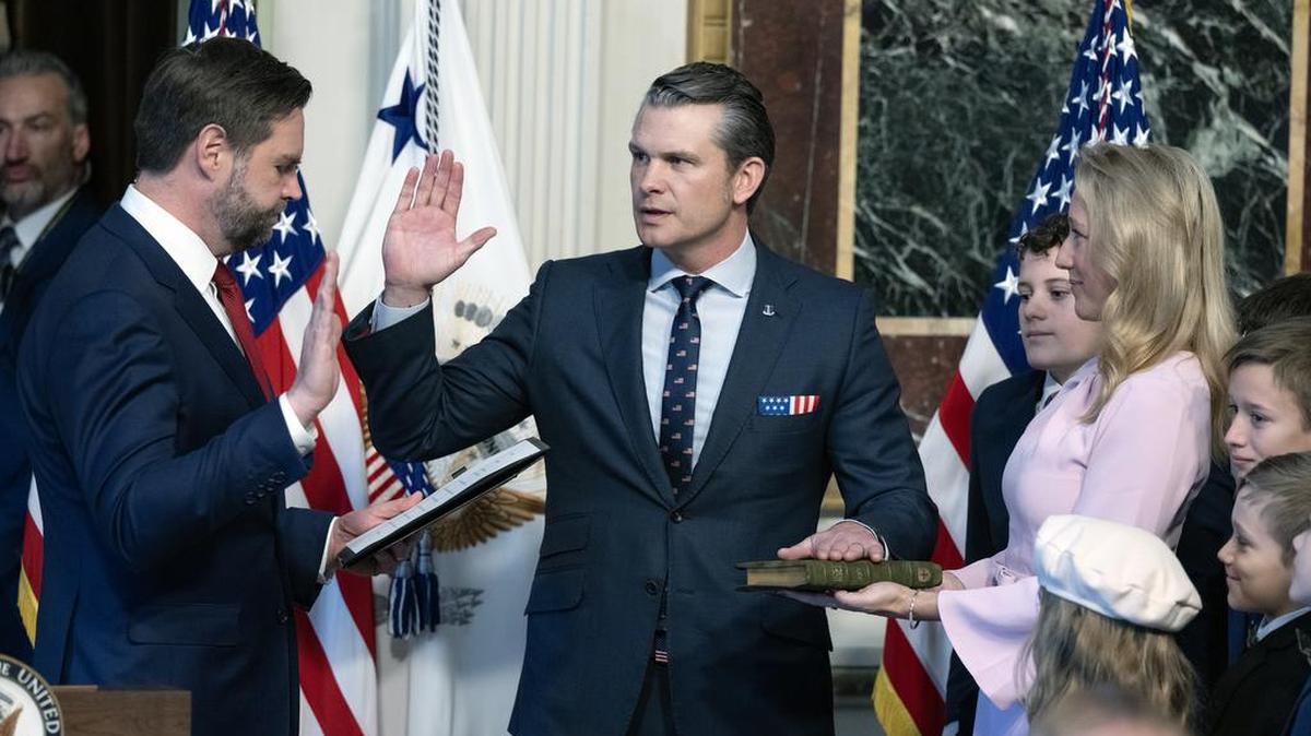 El vicepresidente de los Estados Unidos, J. D. Vance (I), toma juramento al secretario de Defensa de los Estados Unidos, Pete Hegseth (C), en la Sala del Tratado Indio del edificio de la Oficina Ejecutiva de Eisenhower en el campus de la Casa Blanca en Washington, DC, el sábado 25 de enero de 2025. A la derecha, la esposa de Hegseth, Jennifer Rauchet Hegseth, sostiene la Biblia.
