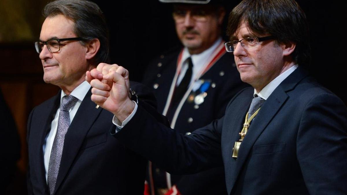 El ex presidente de Cataluña Artur Mas (izq.) junto al nuevo jefe de gobierno regional, el independentista, Carles Puigdemont, en la sede del ejecutivo catalán.