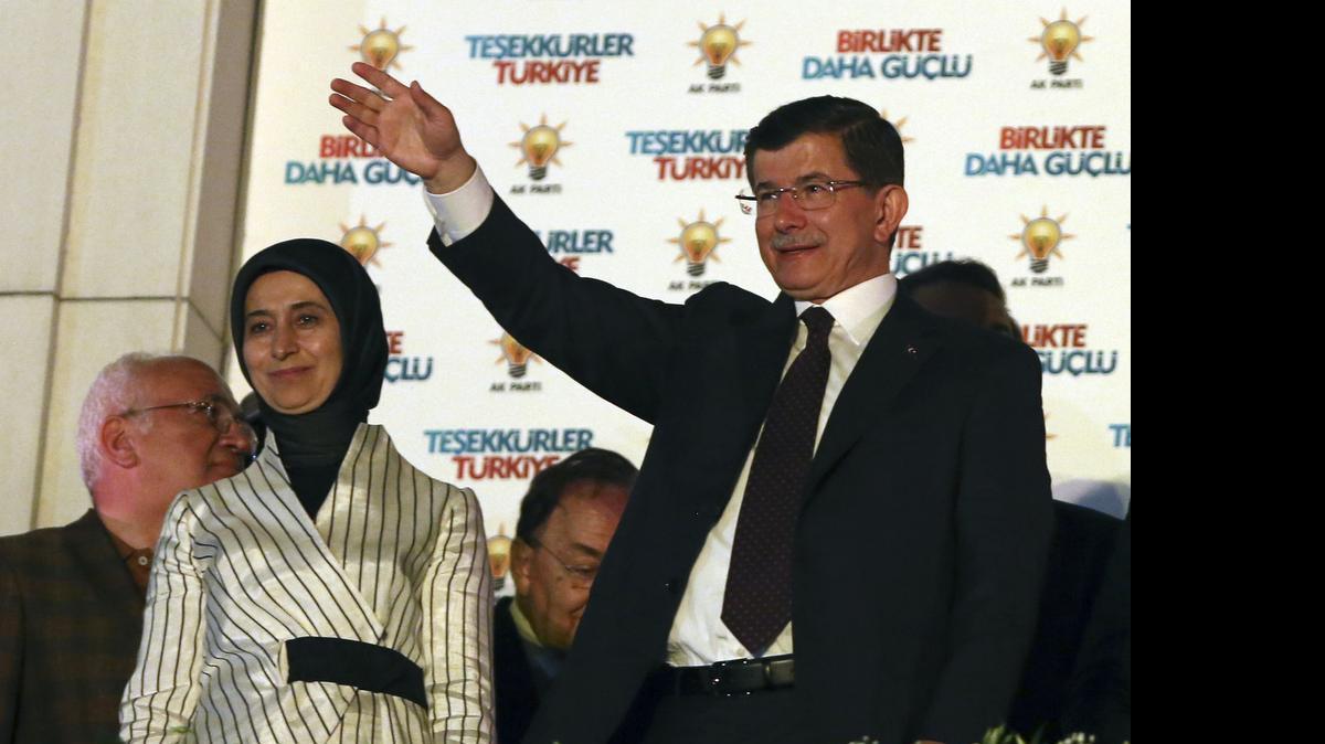 
El primer ministro turco Ahmet Davutoglu, junto a su esposa, saluda a sus seguidores el domingo en Ankara.
