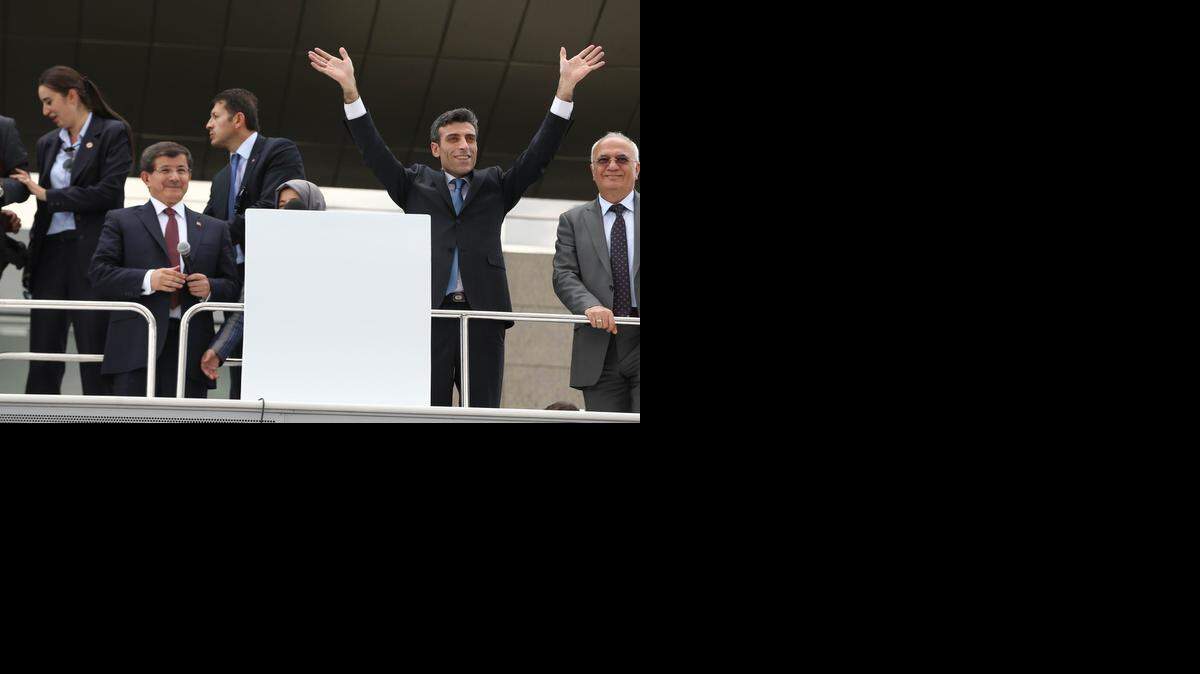 
El consul de Turquí
a en Mosul, Ozturk Yilmaz (con los brazos en alto), saluda a la multitud junto al primer ministro Pavos Ahmet Davutoglu (izq.), este sábado.
