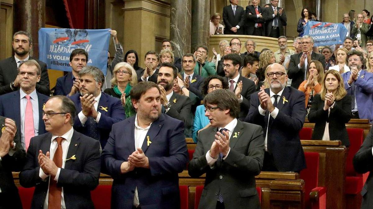 El presidente de la Generaliatat, Carles Puigdemont (d) y el vicepresidente del Govern y conseller de Economía, Oriol Junqueras (2d), junto a los diputados de JxSí y la CUP y sin los diputados del PSC, PPC y Ciudadanos, aplauden tras aprobarse en el pleno del Parlament, la declaración de independencia.