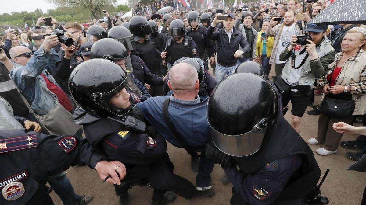Miembros de la policía detienen a uno de los participantes de la manifestación no autorizada en los campos de Marsovo en San Petersburgo, Rusia, el 12 de junio de 2017. Más de 250 personas ya han sido detenidas en las marchas de protesta no autorizadas convocadas hoy por el líder opositor Alexéi Navalni contra la corrupción, según distintas fuentes.