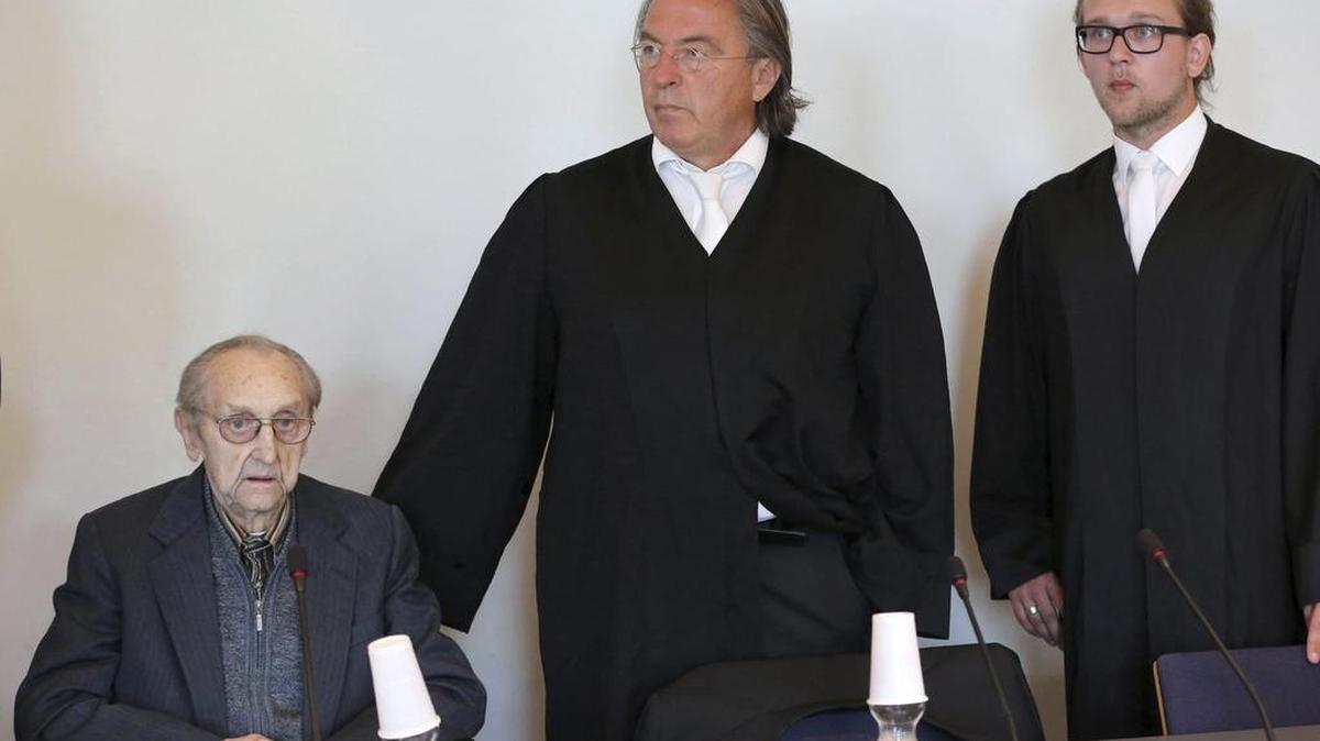 Un ex enfermero de las SS en el campo de exterminio de Auschwitz, el acusado Hubert Z., espera junto a sus abogados en una sala de la Audiencia Provincial de Neubrandenburg, al este de Alemania, hoy, 12 de septiembre de 2016.