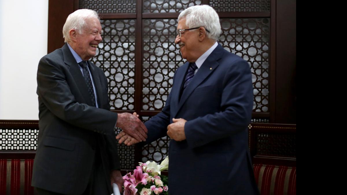 
El ex presidente de EEUU Jimmy Carter estrecha la mano del presidente palestino Mahmoud Abbas en Ramallah. 
