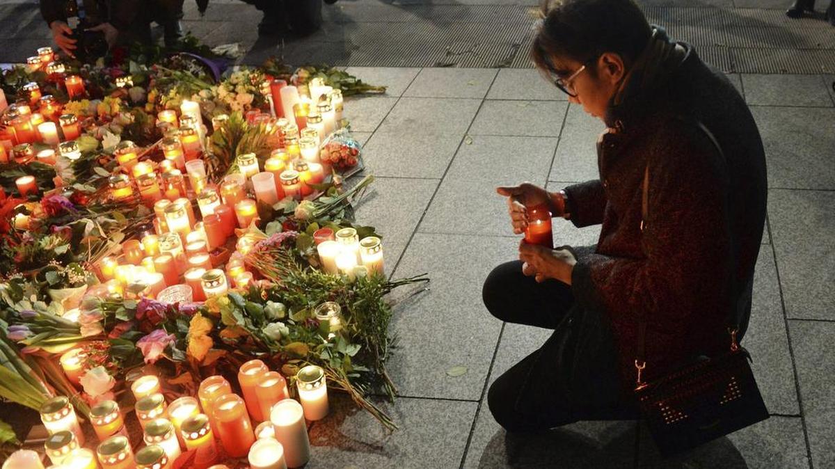 Un hombre deja una vela en el lugar del atentado en Berlín, Alemania, el 20 de diciembre de 2016. Al menos doce personas murieron este lunes y unas cincuenta resultaron heridas al ser arrolladas por un camión que irrumpió en un mercadillo navideño del centro de Berlín, objetivo presuntamente de un atentado.