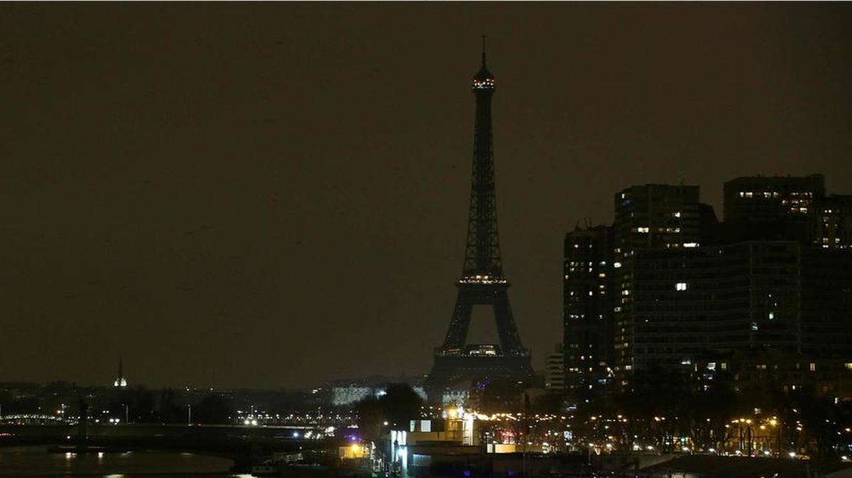 Un combo de fotos muestra a la Torre Eiffel en París antes y después de que se apagaran las luces para la campaña ambiental Hora de la Tierra el 19 de marzo de 2016.