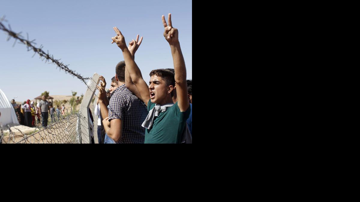 
Cientos de kurdos protestan contra el Estado Islámico cerca de Sanliurfa, Turquía, el sábado. Yihadistas del EI atacaron el pueblo kurdo Kobane el viernes.
